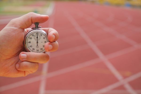 Old stopwatch in a hand in a running track